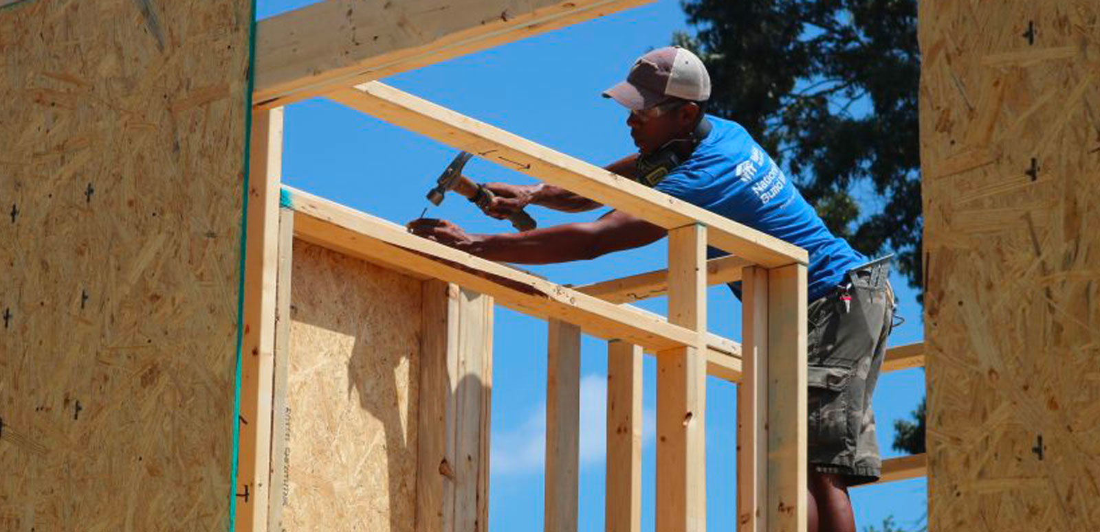 Man with hammer on house frame